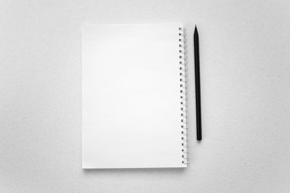 Spiral notebook with blank pages and pencil on white surface. Perfect for mockups or stationery themes.