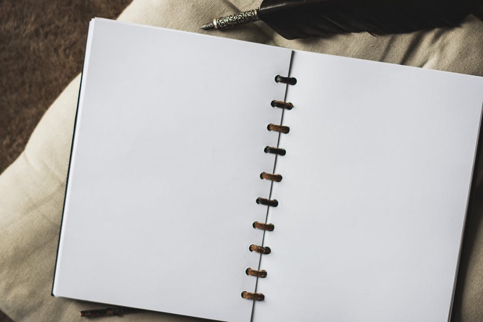 An empty notebook with vintage quill pen, ready for notes.