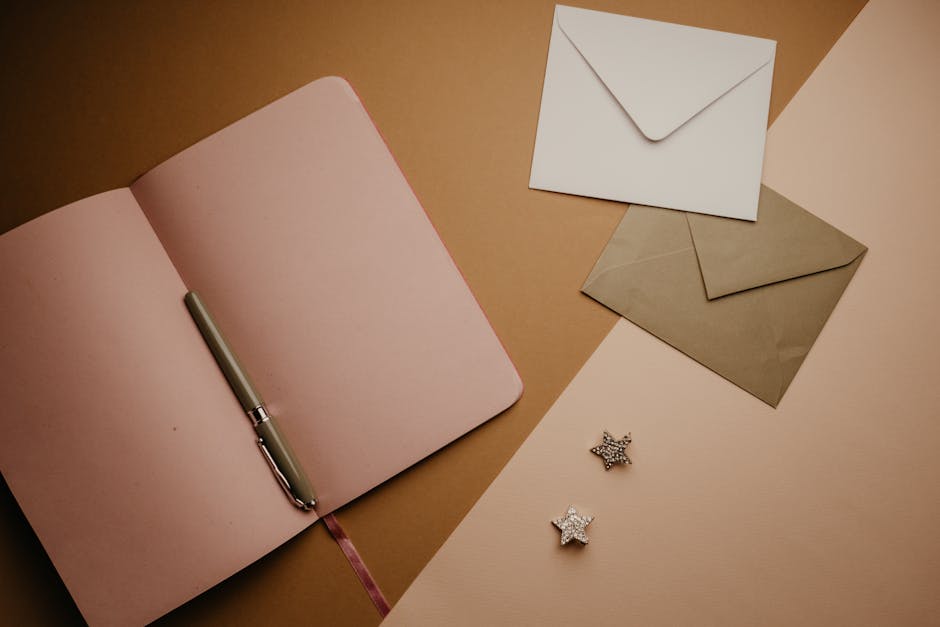 A stylish flat lay featuring an open notebook, envelopes, and a pen, perfect for stationery enthusiasts.